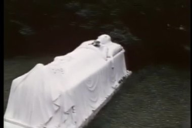 bir kadın çiçek tutan bir yatakta yatmak şeklinde mezar taşı