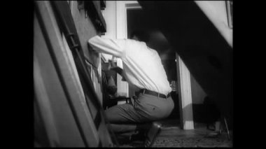 Adam bir ahşap tahta merdiven korkuluk arasında 1960'larda çivileme.
