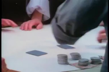 Kağıt oynarken bir adamın elini şapırdattığı orta boy bir fotoğraf.
