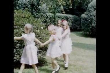 Çocuklar parkta çember şeklinde oynuyorlar.