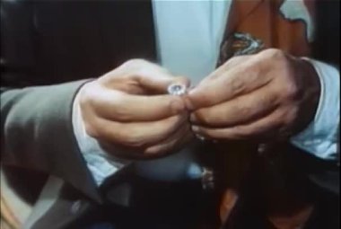1960 'larda erkek ellerinin parlak bir yüzük tutuşu.