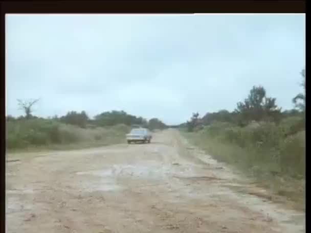 1970年代の汚れた道路で停車する警察車 — ストック動画