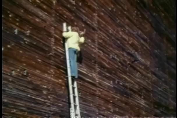 壁に槌で打つ脚立の男 — ストック動画