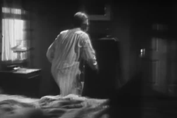 1940 年代のライフルをつかむためベッドから出てくる男性 — ストック動画