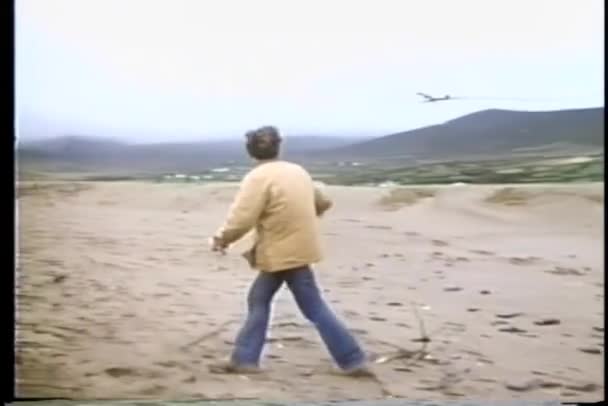 Mann Steht Strand Und Beobachtet Rauchendes Flugzeug — Stockvideo