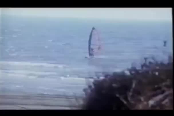 Panorering Windsufer Som Han Glider Mot Stranden — Stockvideo