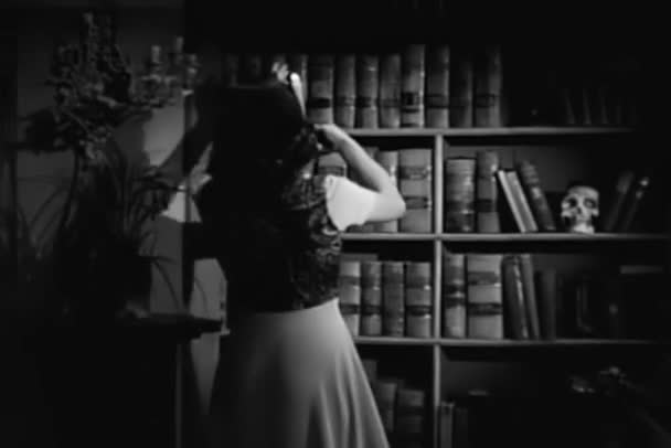 Rear View Woman Candle Searching Bookshelf 1940S — Stock Video