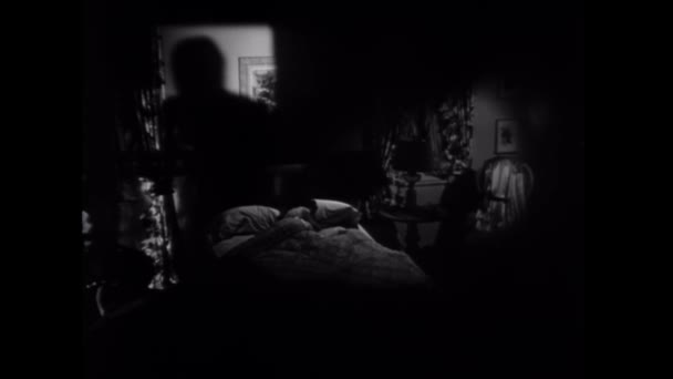 ベッドで寝ている女性に向かって動く男の影 — ストック動画