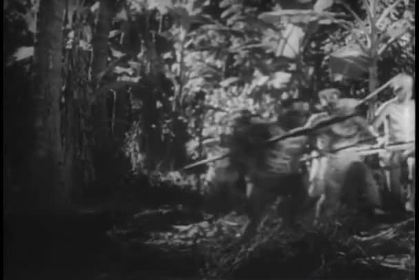 Γηγενείς Πολεμιστές Τρέχει Μέσα Από Ζούγκλα Και Γλιστρήσουν Φύλλα Μπανάνας — Αρχείο Βίντεο