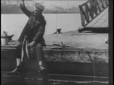 Yaşlı bir adam 1920 'lerde iskelede balık tutuyor.