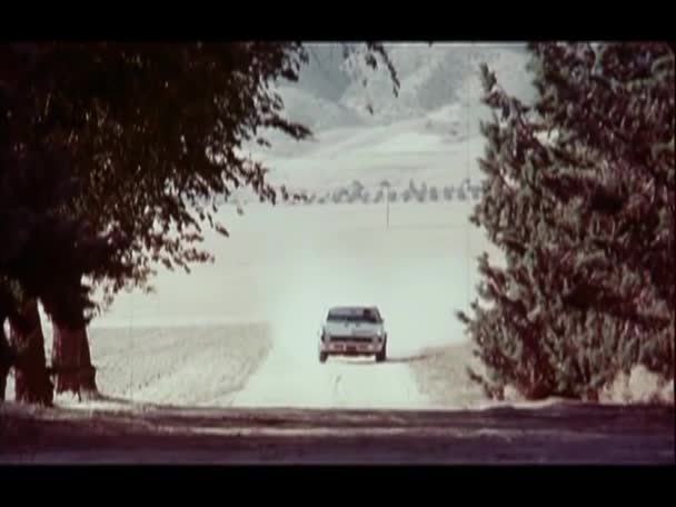 汚れた道を運転し 家の前で停止する車 1970年代 — ストック動画