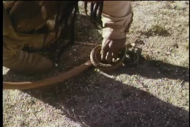 ネイティブアメリカンの男が蛇を拾って袋に入れた — ストック動画