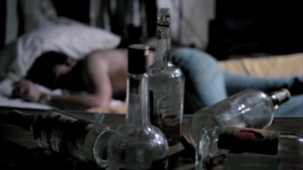 Bouteilles Alcool Vides Sur Table Avec Homme Dormant Arrière Plan — Video