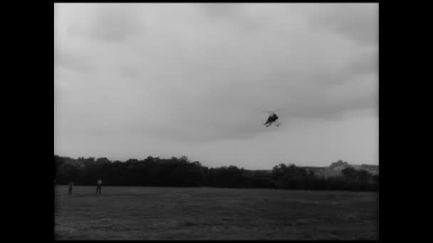 Ελικόπτερο Που Προσγειώνονται Δίπλα Από Μια Ομάδα Ανθρώπων Στον Τομέα — Αρχείο Βίντεο