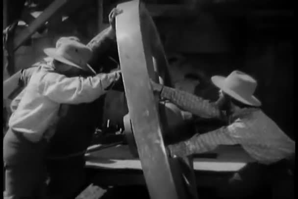 Men Moving Large Wooden Wheel Stock Footage