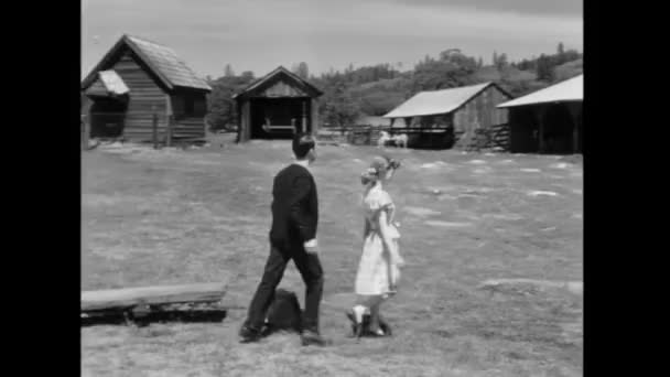 納屋に向かって歩く若いカップルの背面図 — ストック動画