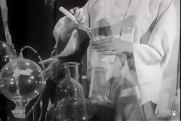 实验室技术员中镜头向瓶中注入粉末 二十世纪五十年代 — 图库视频影像