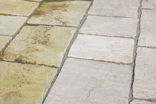 Cleaning sandstone paving. Garden patio before and after jet washing or pressure washing, UK.