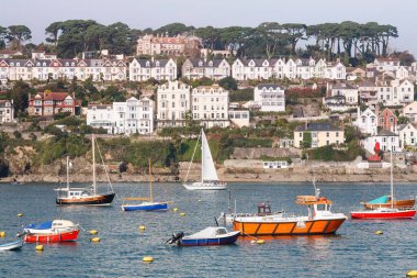 CORNWALL, UK - October 12, 2008. Boats moored in Fowey harbour with houses on the seafront. Fowey, Cornwall, UK