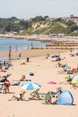 BOURNEMOUTH, UK - July 08, 2022. Sunbathers on a sandy beach in summer on the south coast of England. Bournemouth beach, Dorset, UK