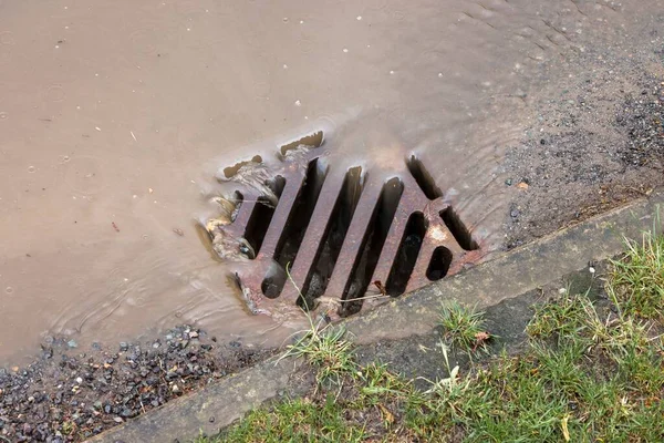 Regenwasser Fließt Nach Starkem Regen Einen Straßenabfluss Hinunter Großbritannien — Stockfoto