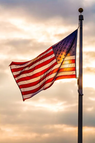 星とストライプ フラッグポールに飛ぶアメリカの国旗 空に対する日光でバックライト — ストック写真