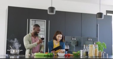 Çeşitli çiftlerin yemek hazırlayıp evde tablet kullandıkları videolar. Ev hayatı, aşk, sağlık, mutluluk ve kapsayıcılık kavramı.