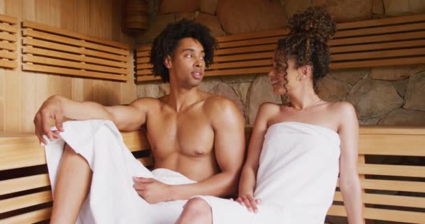 Vídeo Casal Diverso Descontraído Usando Toalhas Sentadas Conversando Sala Sauna — Vídeo de Stock