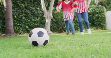 Bahçede futbol oynayan anne ve kızının düşük seviyeli videosu. Aile, annelik, ilişkiler ve birlikte kaliteli zaman geçirme konsepti dijital olarak oluşturulmuş video.