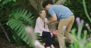 Güneşli bir günde bahçede piknik yapan mutlu çift. Ev kavramında kaliteli zaman geçirmek.