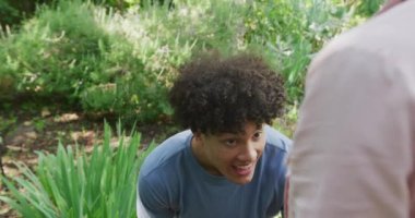 Güneşli bir günde bahçede evlenme teklif eden ve gülümseyen mutlu çift. Düğün, parti ve kutlama konsepti.