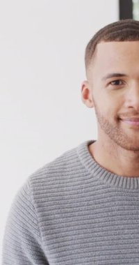 Kameraya gülümseyen melez bir adamın yarı yarıya dikey portresi ve fotokopi çekilen kapalı alanda gülüşü. Sağlık, mutluluk, kapsayıcılık ve yaşam tarzı konsepti.