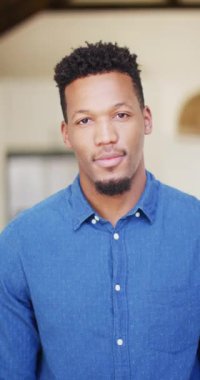 Mutlu Afro-Amerikan bir adamın portresinin dikey videosu. Evde yalnız zaman geçirmek..