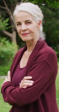 Bahçedeki mutlu beyaz kadın portresinin dikey videosu. Aile evde birlikte vakit geçiriyor..