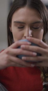 Düşünceli, beyaz bir kadının rahatlayıp kahve içtiği dikey bir video. Ev hayatı, kaliteli zaman geçirmem evde yalnız kalmam..