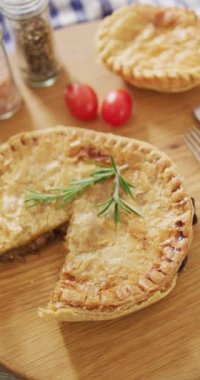 Bir dilimli ve biberiyeli, masada domatesli fırınlanmış baharatlı turtaların dikey videosu. ev yapımı yemek, diyet ve beslenme.