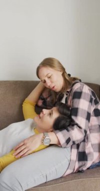 Kafkasyalı mutlu lezbiyen çiftin evde kucaklaştığı dikey video. Evde birlikte vakit geçirmek..