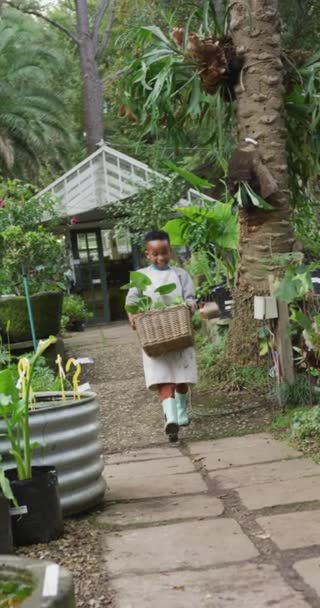 Verticale Video Van Afrikaanse Amerikaanse Jongen Die Planten Tuin Houdt — Stockvideo
