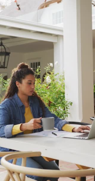 Vídeo Vertical Mujer Biracial Feliz Bebiendo Café Utilizando Ordenador Portátil — Vídeo de stock