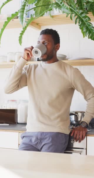 Vídeo Vertical Del Hombre Afroamericano Feliz Bebiendo Café Cocina Pasar — Vídeos de Stock