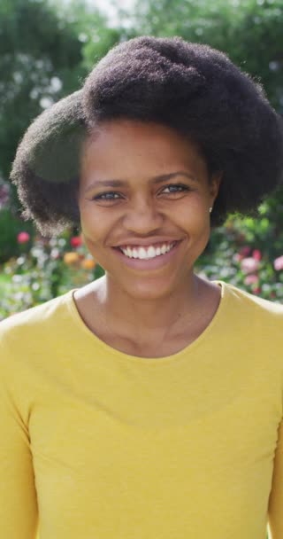 庭で笑顔アフリカ系アメリカ人女性の垂直ビデオ肖像画 家庭での身体的包容力国内生活と質の高い時間 — ストック動画