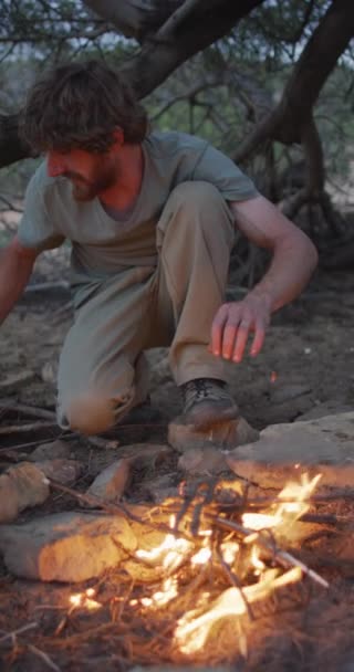 长胡子的高加索男性幸存者在野外生火的垂直录像 身体的包容性 探索和自然生存 — 图库视频影像
