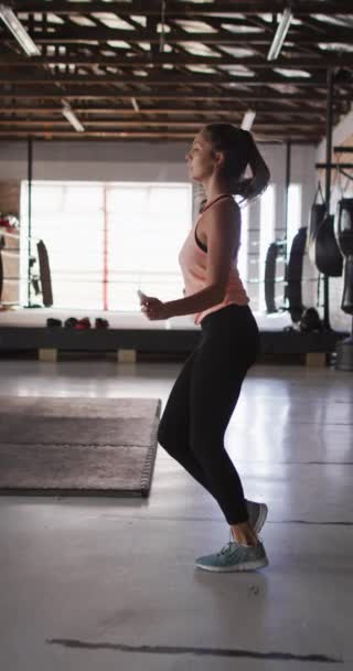健康的高加索女人在体育馆跳跳绳的垂直视频 积极的 健康的 运动的 健康的生活方式 — 图库视频影像