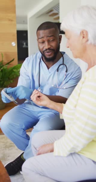 幸せなアフリカ系アメリカ人男性医師の垂直ビデオ高齢者と話しています 高齢者の健康と介護ホームライフスタイルのコンセプト — ストック動画