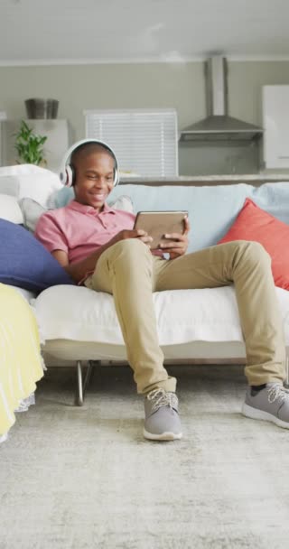 Vídeo Vertical Menino Americano Africano Feliz Fones Ouvido Usando Tablet — Vídeo de Stock