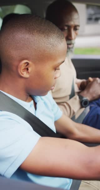 運転レッスン中のアフリカ系アメリカ人の父親と息子の垂直ビデオ 運転のレッスンと一緒に時間を過ごす — ストック動画