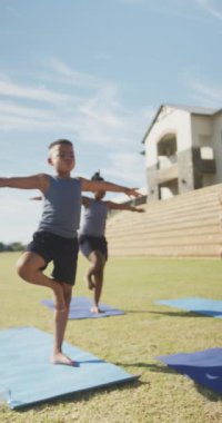 Okulda egzersiz yapan mutlu çocukların dikey videosu. okul ve eğitim ve beden bütünlüğü.