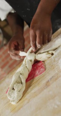 Pastanede hamur hazırlayan Afro-Amerikan erkek fırıncının dikey videosu. küresel iş ve fırın.