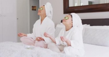 Mutlu Asyalı anne ve kızının salatalık maskesi takıp dinlendiği bir video. Aile, annelik, ilişkiler ve birlikte kaliteli zaman geçirme konsepti dijital olarak oluşturulmuş video.