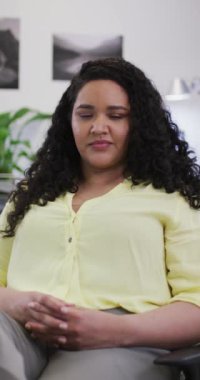 İşteki gülümseyen melez kadının dikey video portresi. Yaratıcı bir işte, iş yerinde bedensel bütünlük.